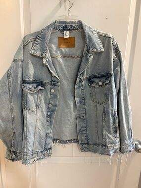 Light wash oversized distressed denim jacket with raw hem detail 🤍